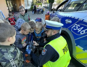 Policjanci rozmawiają z przedszkolakami o bezpieczeństwie na drodze.