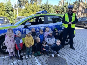 Policjanci rozmawiają z przedszkolakami o bezpieczeństwie na drodze.