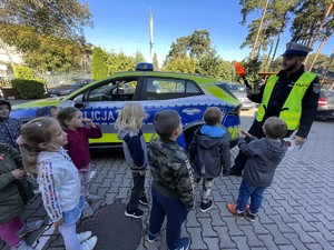 Policjanci rozmawiają z przedszkolakami o bezpieczeństwie na drodze.
