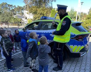Policjanci rozmawiają z przedszkolakami o bezpieczeństwie na drodze.