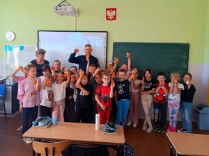 Policjant rozdaje dzieciom odblaski.