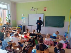 Policjant rozdaje dzieciom odblaski.