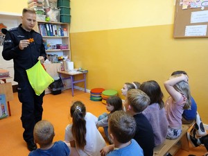 Policjant rozdaje dzieciom odblaski.