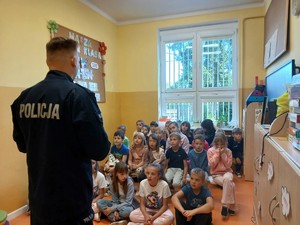 Policjant rozdaje dzieciom odblaski.