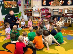 Policjant rozdaje dzieciom odblaski.