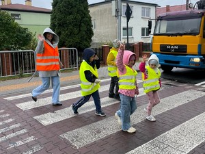 Policjaci z dziećmi prowadzą działania na drodze.