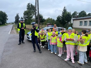 Policjaci z dziećmi prowadzą działania na drodze.