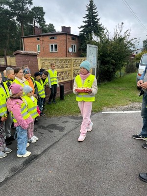 Policjaci z dziećmi prowadzą działania na drodze.