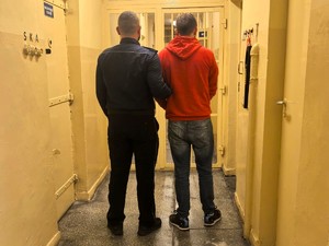 Policjant stoi z osobą poszukiwaną.