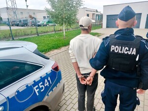 Policjant stoi z osobą poszukiwaną.