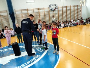 Policjant rozmawia z dziećmi.