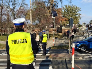 Policjanci kierują ruchem w rejonie przejścia dla pieszych.