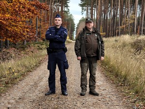 Policjanci razem ze strażą leśną patrolują las.