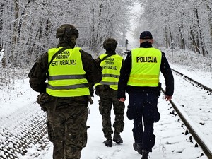 Policjant razem z żołnierzami patroluje rejon torowisk.