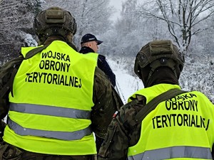 Policjant razem z żołnierzami patroluje rejon torowisk.
