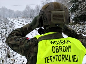Policjant razem z żołnierzami patroluje rejon torowisk.