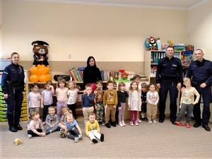 Policjanci rozmawiają z małymi dziećmi.