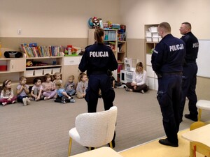 Policjanci rozmawiają z małymi dziećmi.