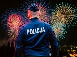 Policjant a w tle fajerwerki.