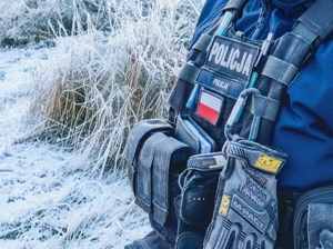 Elementy policyjnego munudru, w tle śnieg na trawie.