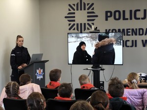 Policjantka rozmawia z dziećmi o bezpieczeństwie podczas ferii.