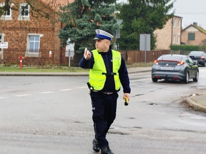 Policjant zatrzymuje pojazd do kontroli.