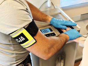 Policjant pobiera odciski palców od kobiety.