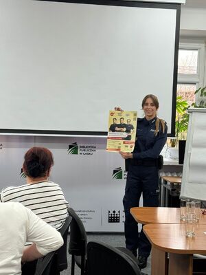 Policjantka rozmawia z seniorami o bezpieczeństwie.