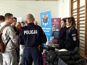 Policjanci rozmawiają z osobami odwiedzającymi ich stoisko promocyjne.