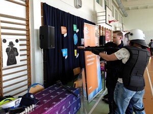 Policjanci rozmawiają z osobami odwiedzającymi ich stoisko promocyjne.