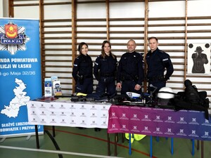 Policjanci rozmawiają z osobami odwiedzającymi ich stoisko promocyjne.