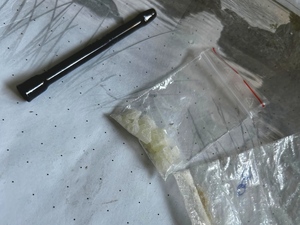 Krystaliczna substacja w woreczku, obok lufka.