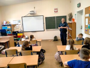 Dzielnicowy rozmawia z dziećmi.
