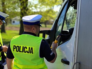 Policjant sprawdza trzeźwość kierującego.