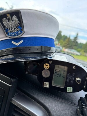 Na desce rozdzielczej samochodu leżą policyjne mierniki prędkości.