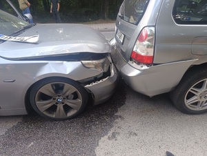 dwa pojazdy uszkodzone, pojazdy koloru szarego. Jedn pojazd najechał na tył drugiego.
