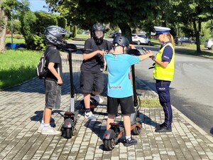 Policjantka kontroluje kierujących hulajnogami.