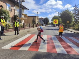 Dziewczyn ka przechodzi przez przejście dla pieszych.