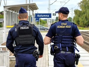 Policjant patroluje rejon dworca razem ze strażnikiem.