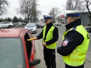 Policjant kontroluje trzeźwość kierującego.