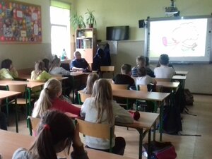 Dzielnicowy opowiada dzieciom o bezpiecznym korzystaniu z internetu.