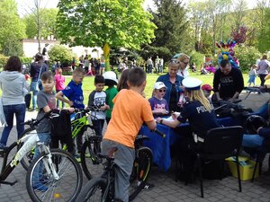 Policjantka rozmawia z dziecmi o bezpieczeństwie w ruchu drogowym.